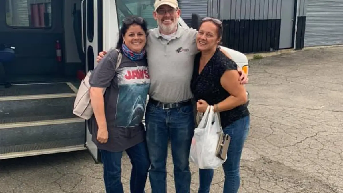 a group of people standing in front of a bus