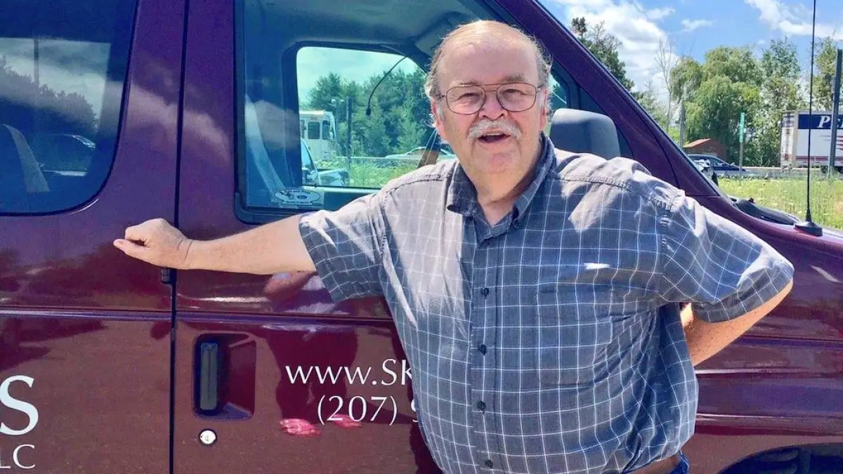 a man standing in front of a car posing for the camera