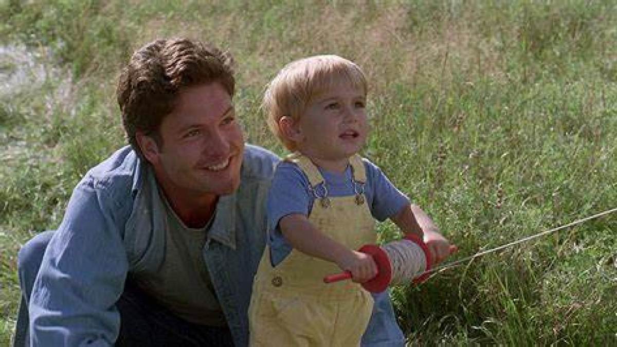 a little boy that is standing in the grass